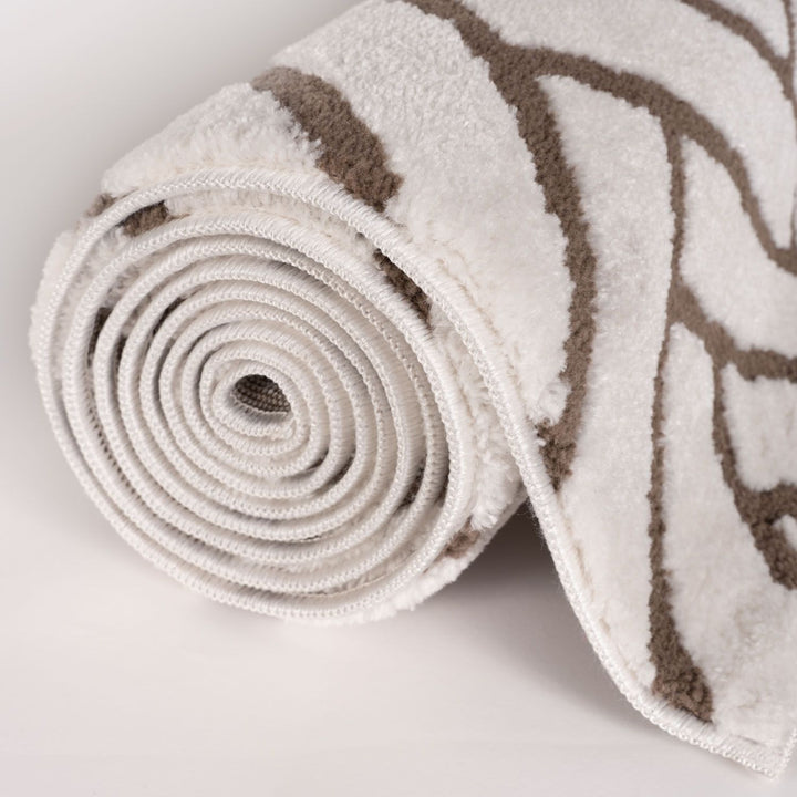 Rolled-up rug with beige and brown pattern on a light gray background