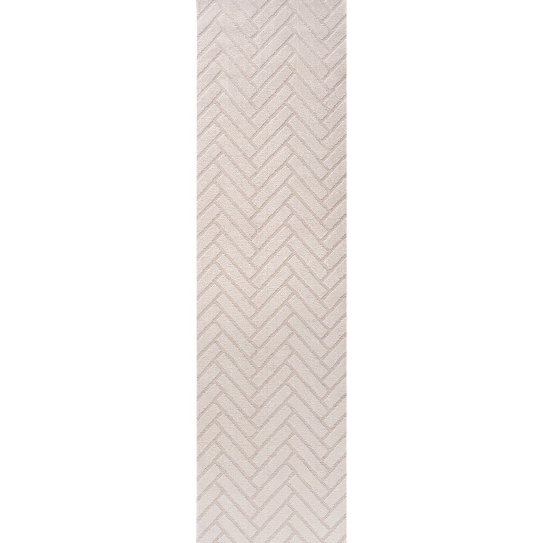 Rectangular area rug with a beige and white chevron pattern on a plain background