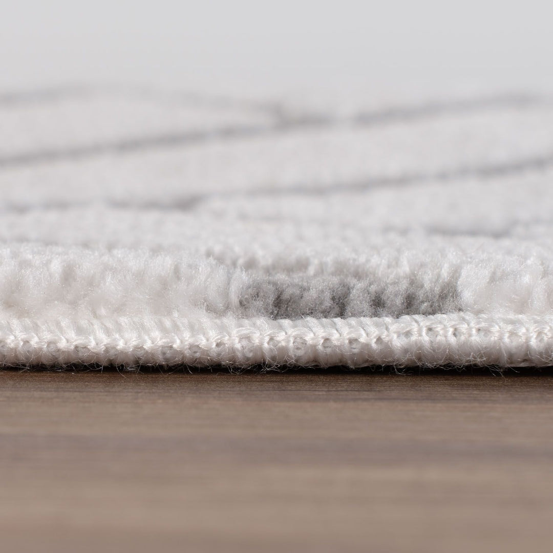 Close-up of a textured gray rug on a wooden floor