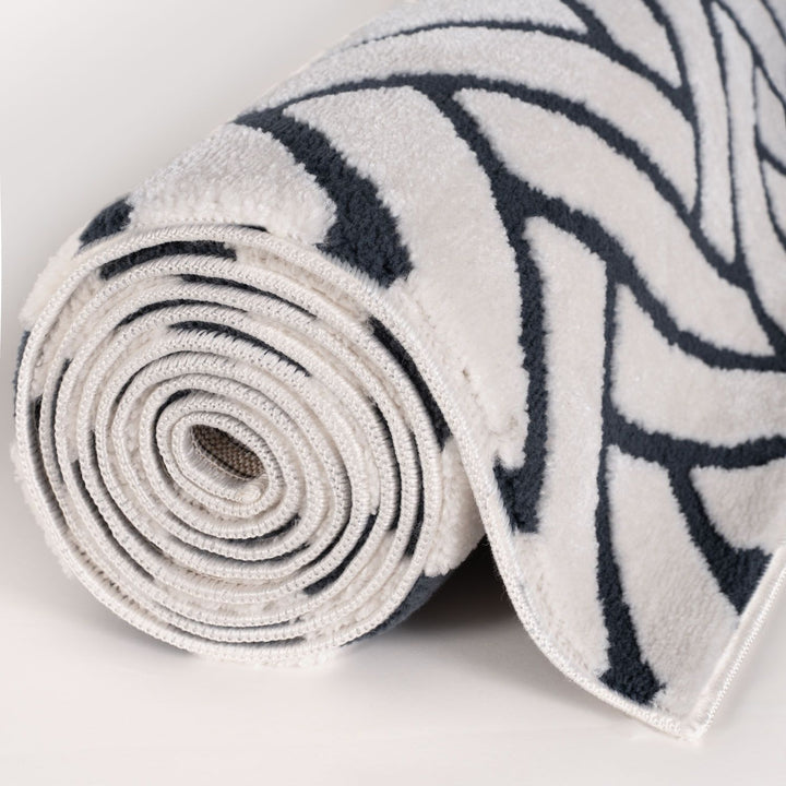Rolled-up rug with black and white pattern on a light gray background