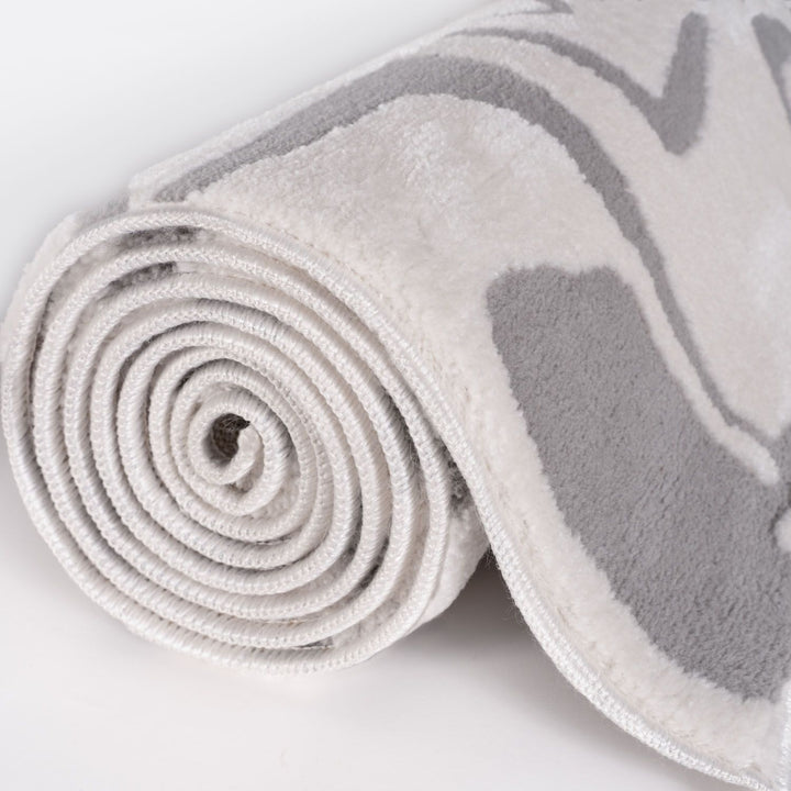 Rolled-up gray and white towel on a light gray background