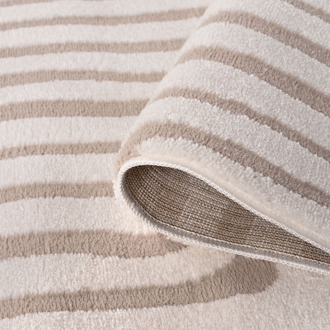 Close-up of a beige and white striped rug with a textured surface.
