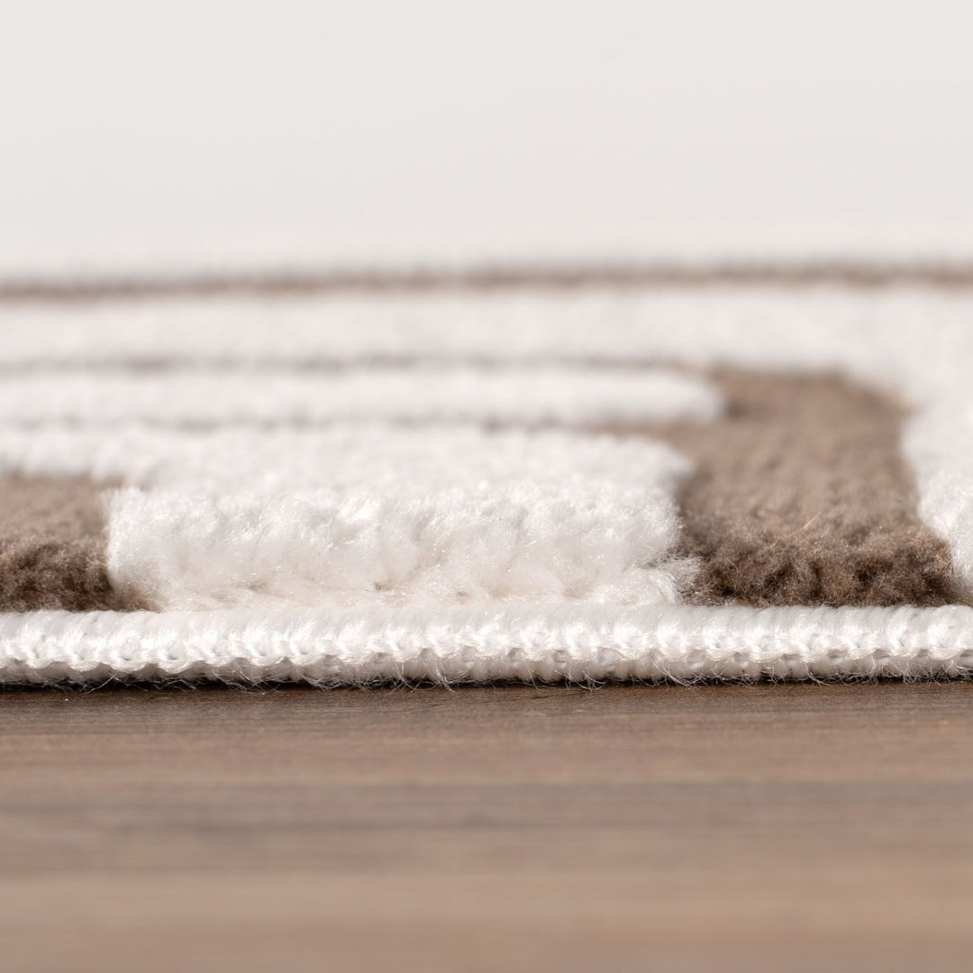 Close-up of a textured rug with brown, white, and beige colors on a wooden floor.