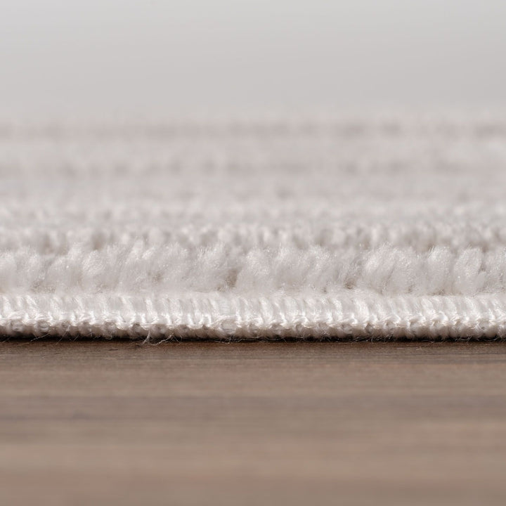 Close-up of a textured rug on a wooden floor