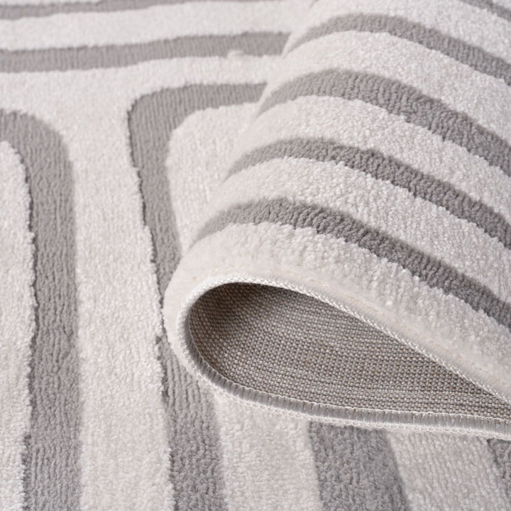 Close-up of a textured gray and white rug with geometric pattern