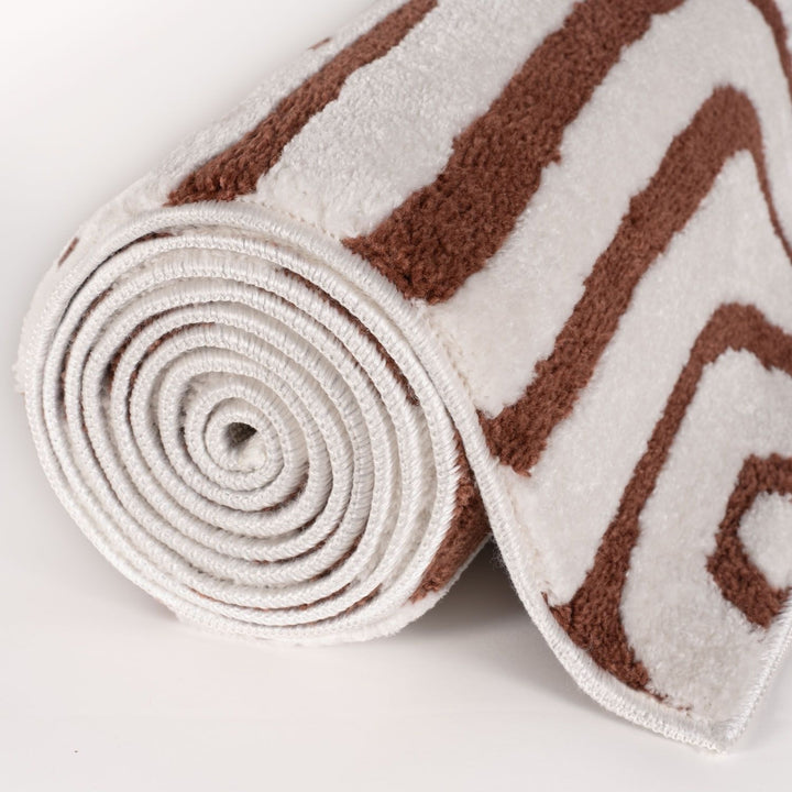 Roll of brown and white patterned fabric on a light gray background