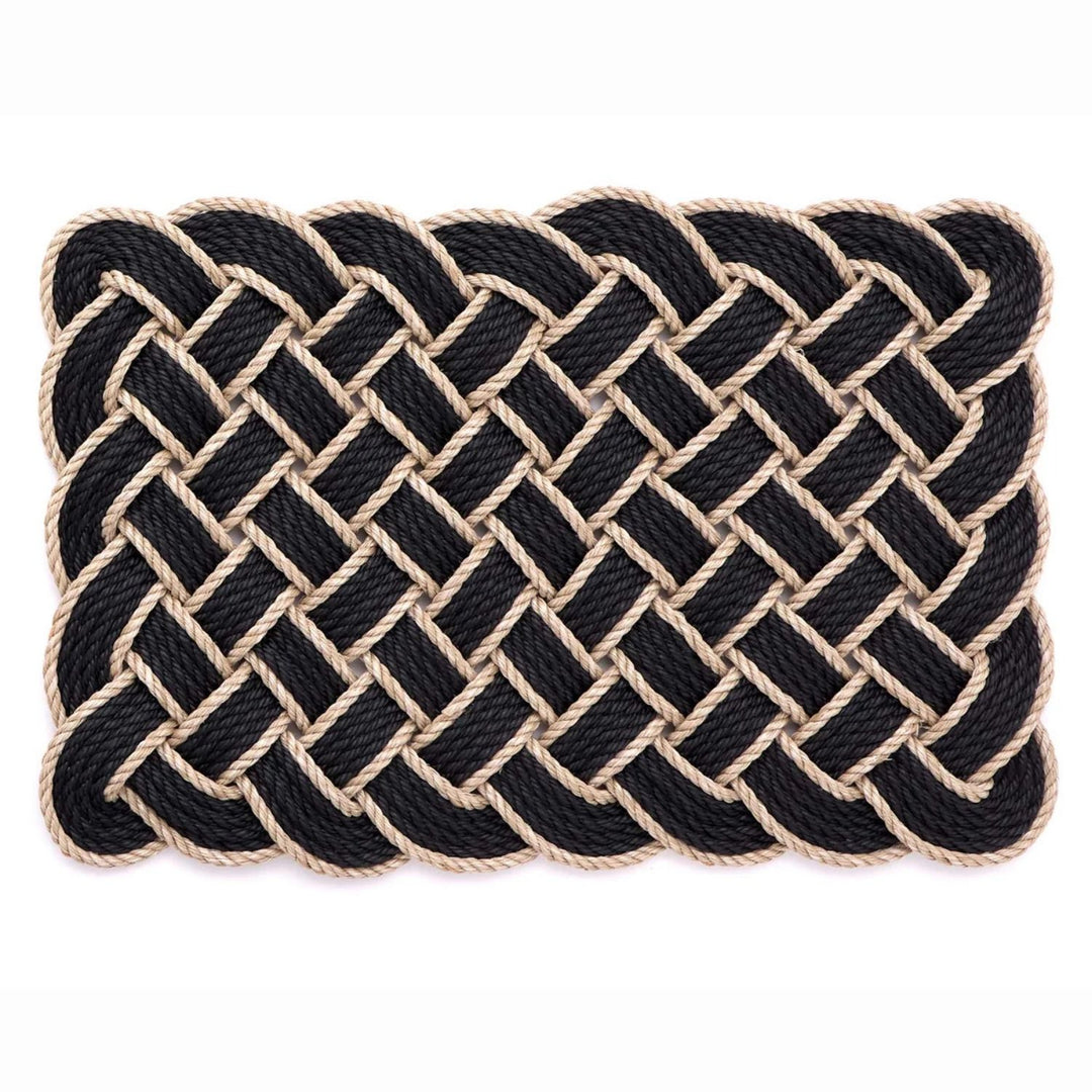 Nautical-style woven mat with black and beige rope on a white background