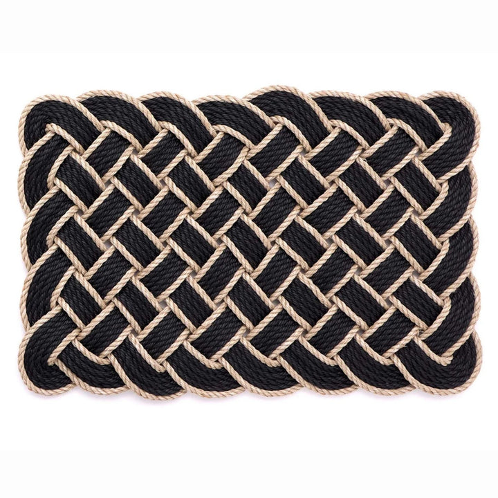 Nautical-style woven mat with black and beige rope on a white background