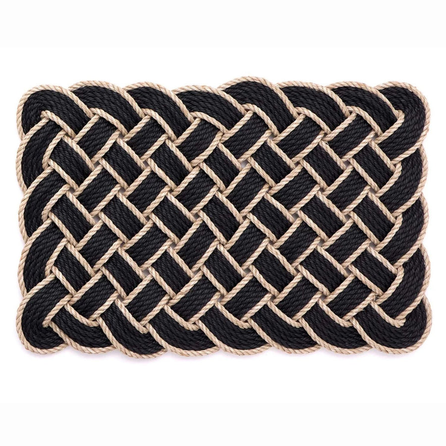 Nautical-style woven mat with black and beige rope on a white background