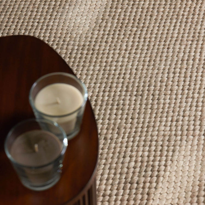 Two candles in glass holders on a textured surface