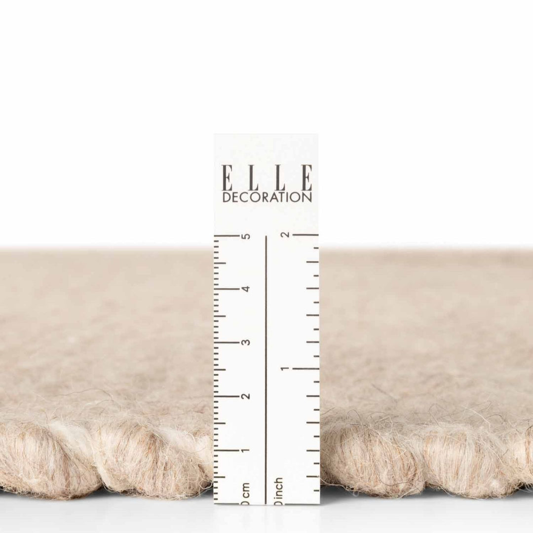 Textured fabric sample with a ruler for measurement and 'ELLE Decoration' branding.
