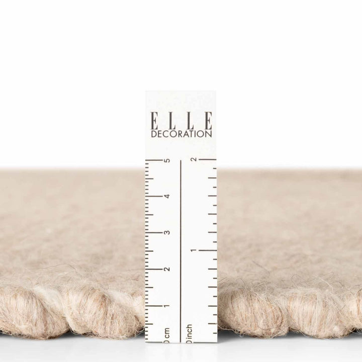Textured fabric sample with a ruler for measurement and 'ELLE Decoration' branding.