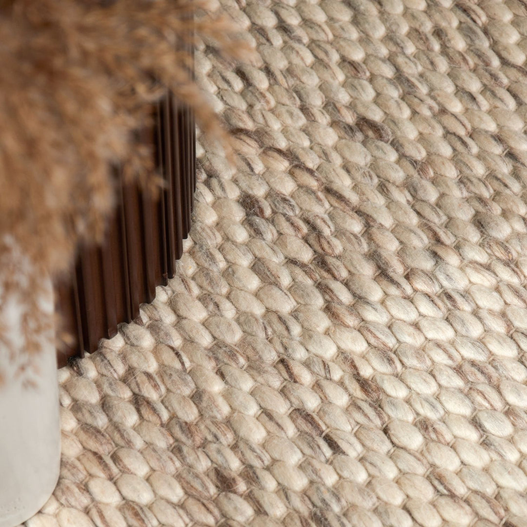 Close-up of a textured beige and brown wall with a decorative metal strip.