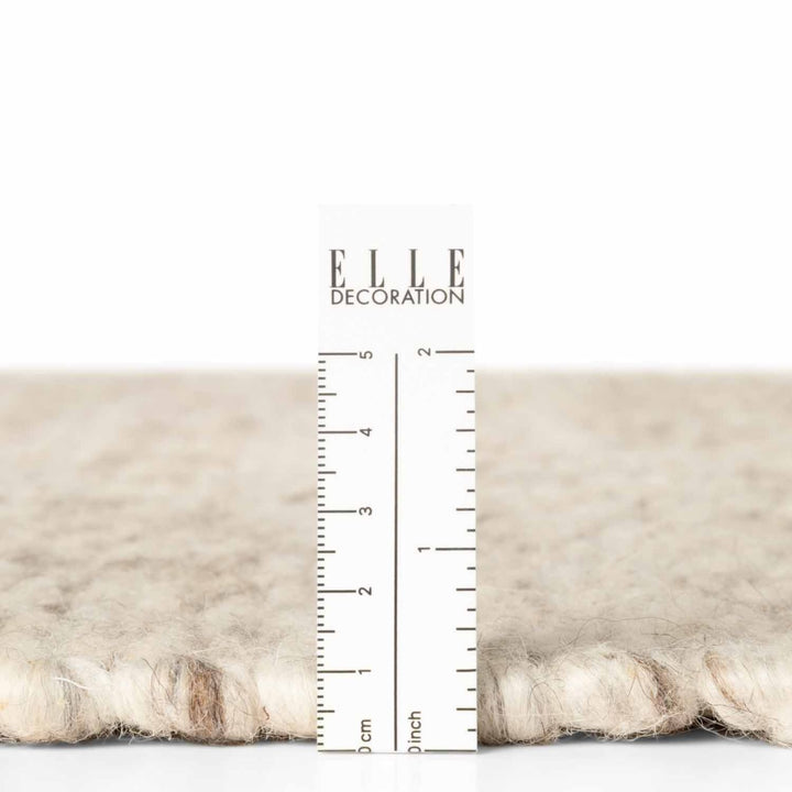Textured fabric with a ruler for scale on a white background, featuring the Elle Decoration logo.