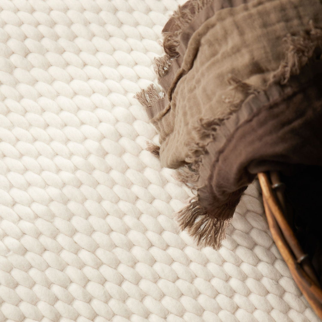 Brown textured rug on a white woven surface