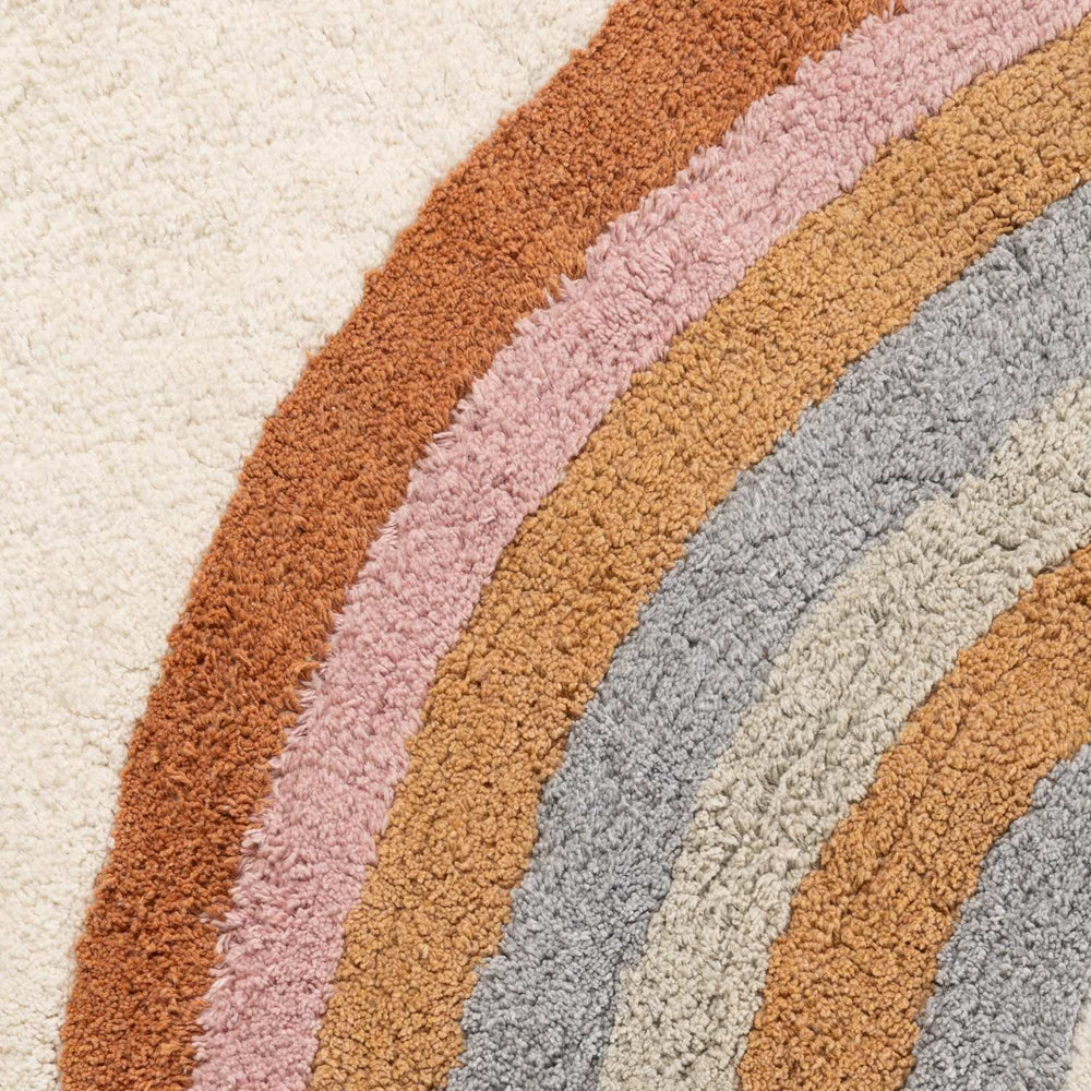 Close-up of a textured rug with wavy pattern in earthy tones.