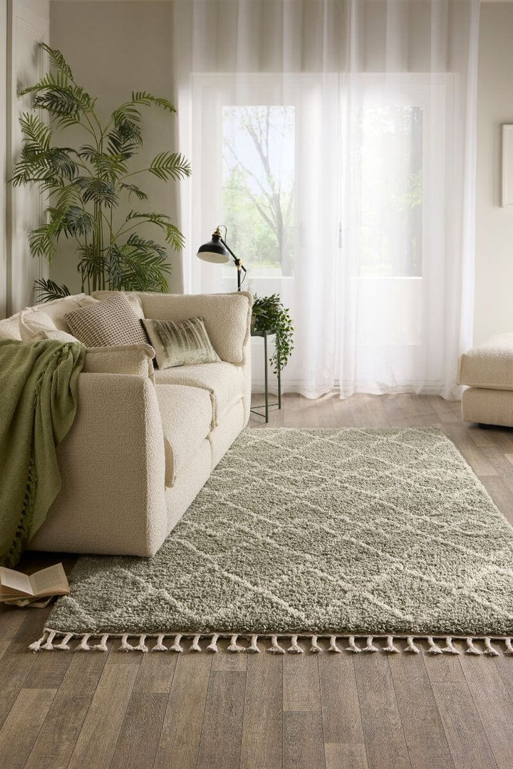 Moroccan style rug in Eucalyptus Green color placed in a modern living room with soft lighting and cozy furniture.