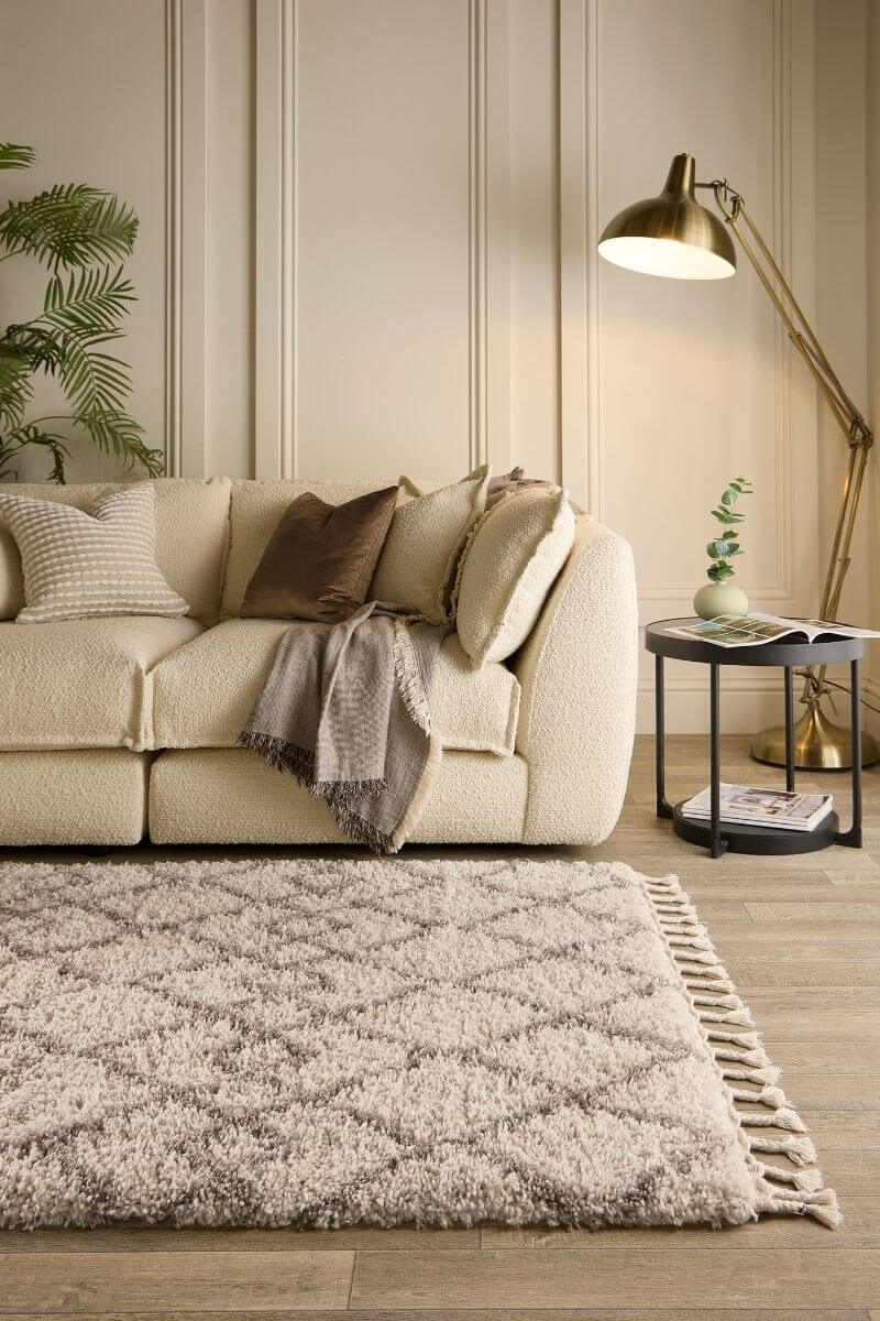 Cozy living room featuring a Moroccan-style rug in soft beige, complemented by a plush sofa and stylish decor.