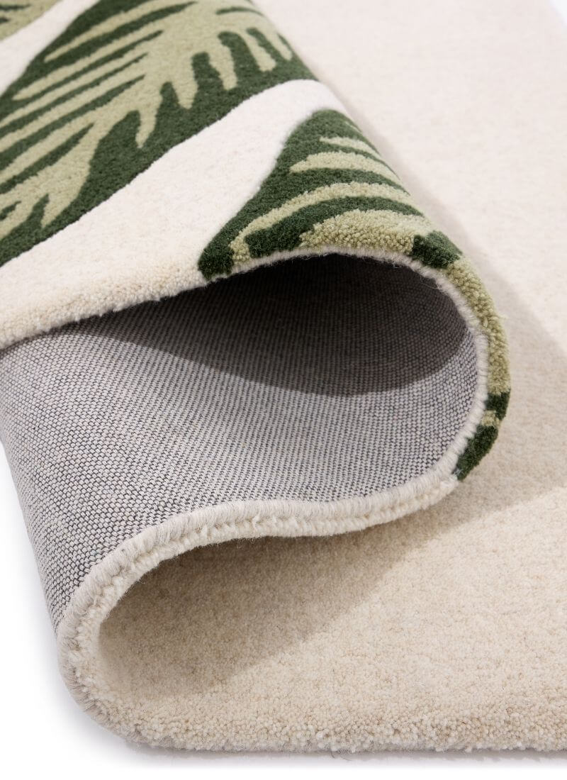 Close-up of Paradise Leaf hand-tufted wool rug showcasing cream and green leaf design with soft texture.