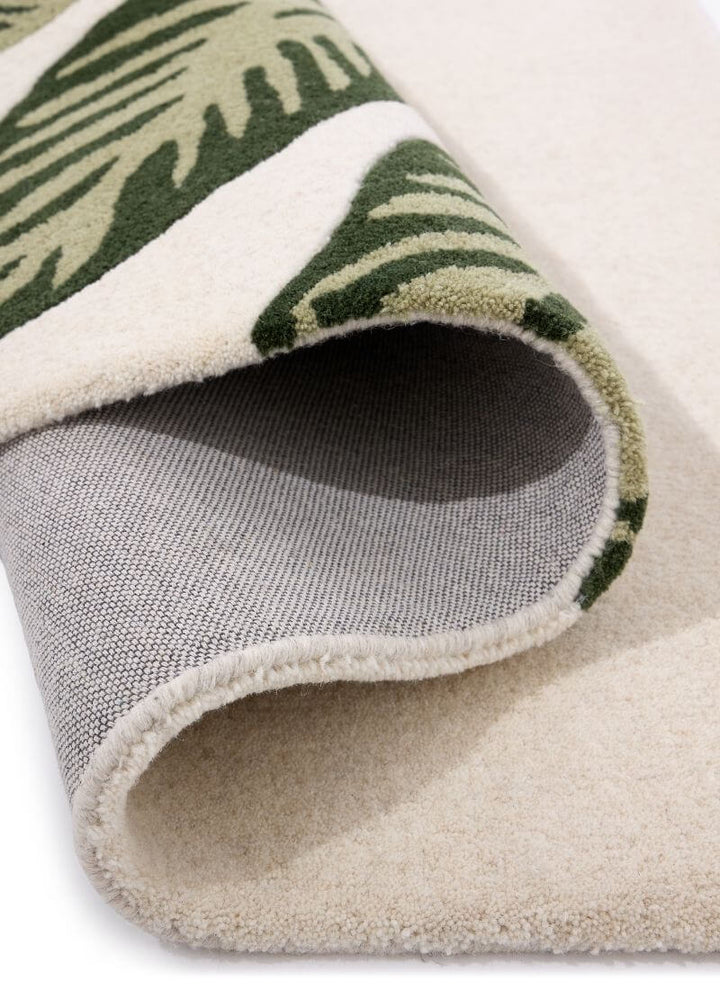 Close-up of Paradise Leaf hand-tufted wool rug showcasing cream and green leaf design with soft texture.