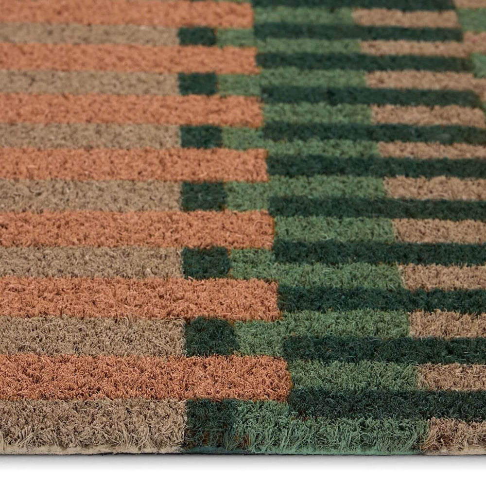 Close-up of a doormat with brown and green striped pattern