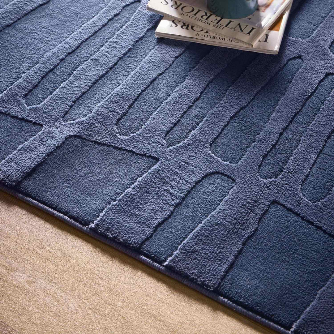 Blue textured rug with a pattern on a wooden floor