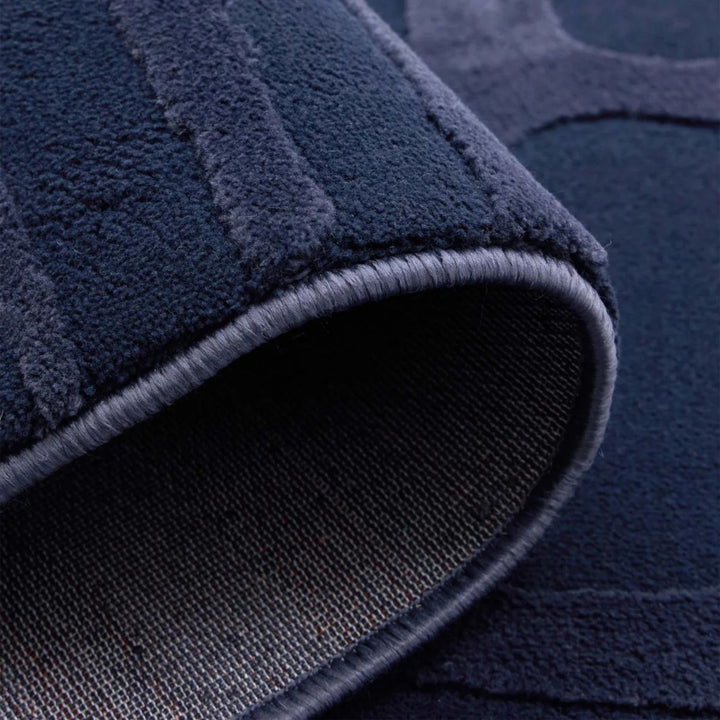 Close-up of a navy blue textured rug corner