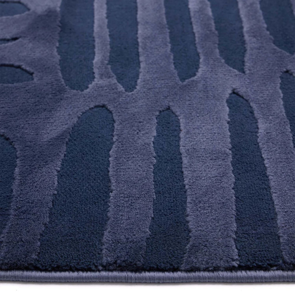 Close-up of a textured blue rug with geometric pattern
