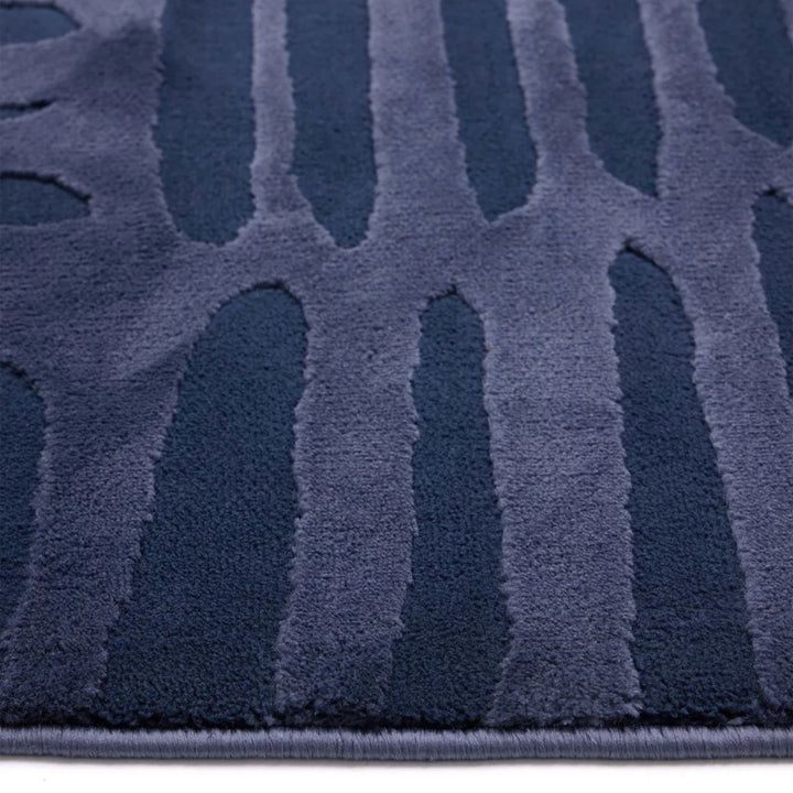 Close-up of a textured blue rug with geometric pattern