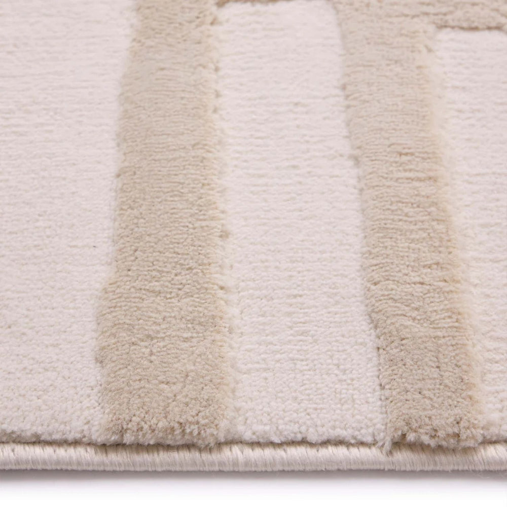 Close-up of a textured rug with beige and white stripes on a light background