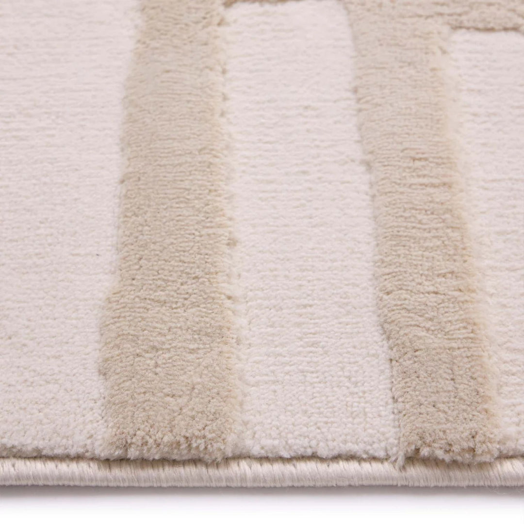Close-up of a textured rug with beige and white stripes on a light background
