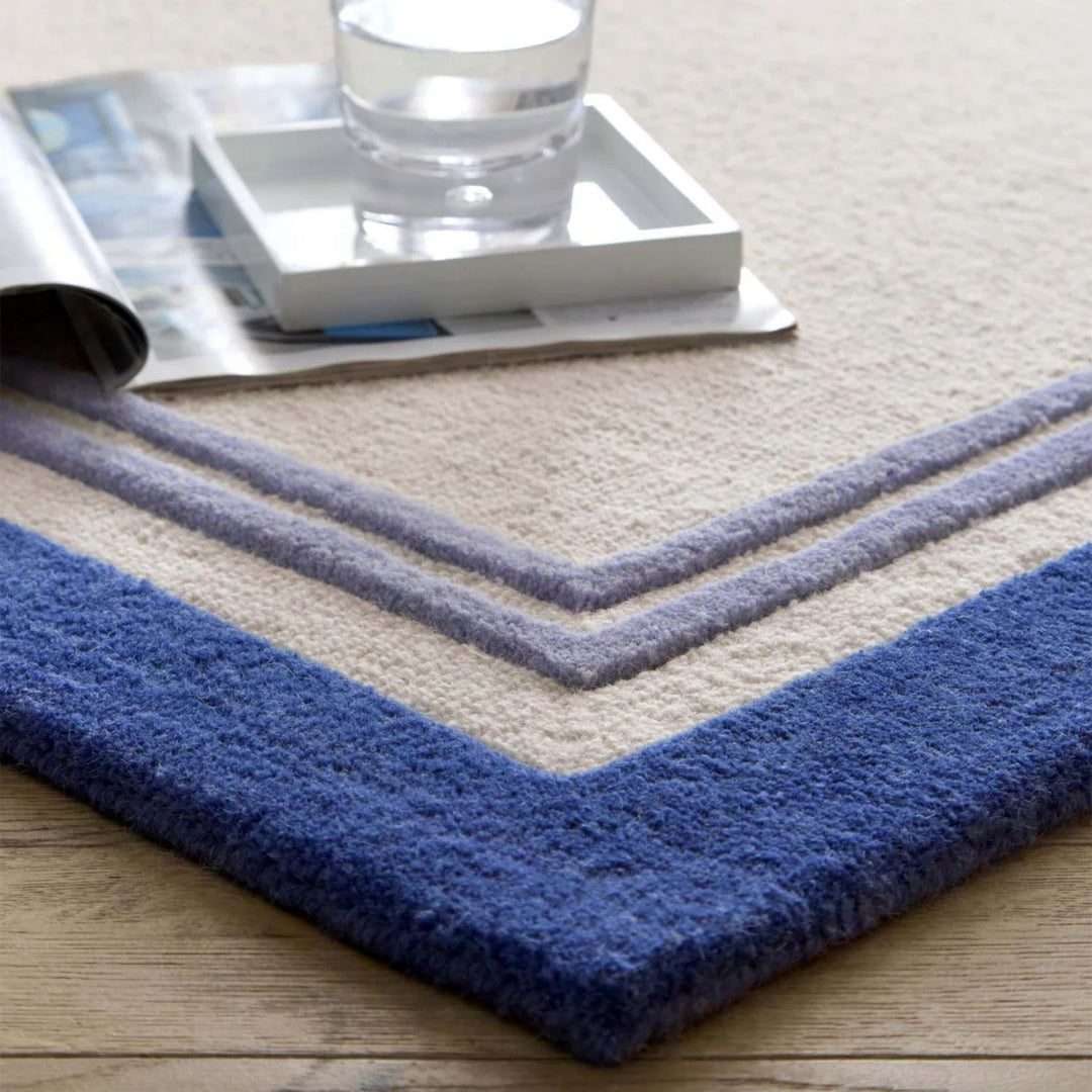 Blue and beige striped rug with a glass of water on top