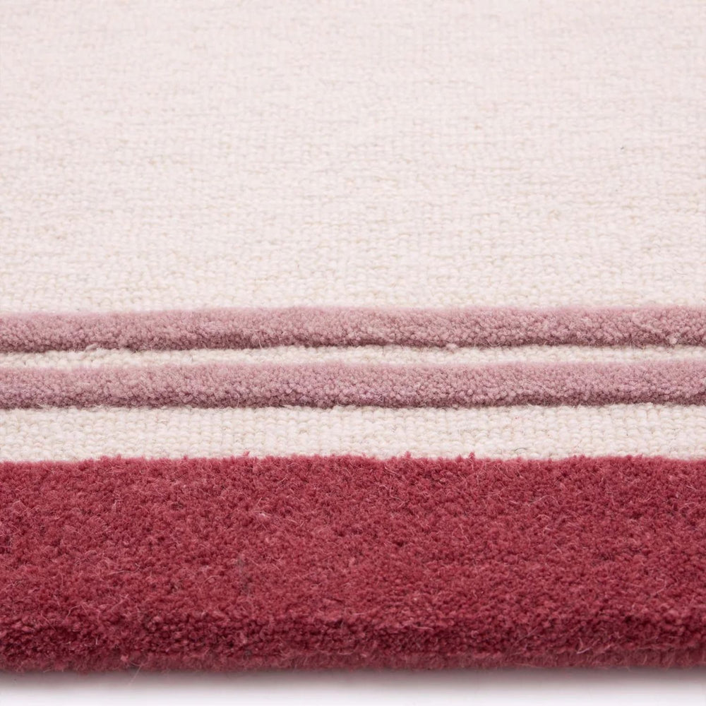 Close-up of a textured fabric with horizontal stripes in pink, white, and red.