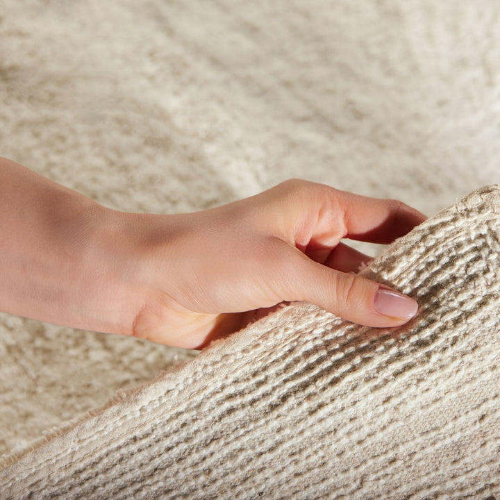 Hand touching textured beige fabric