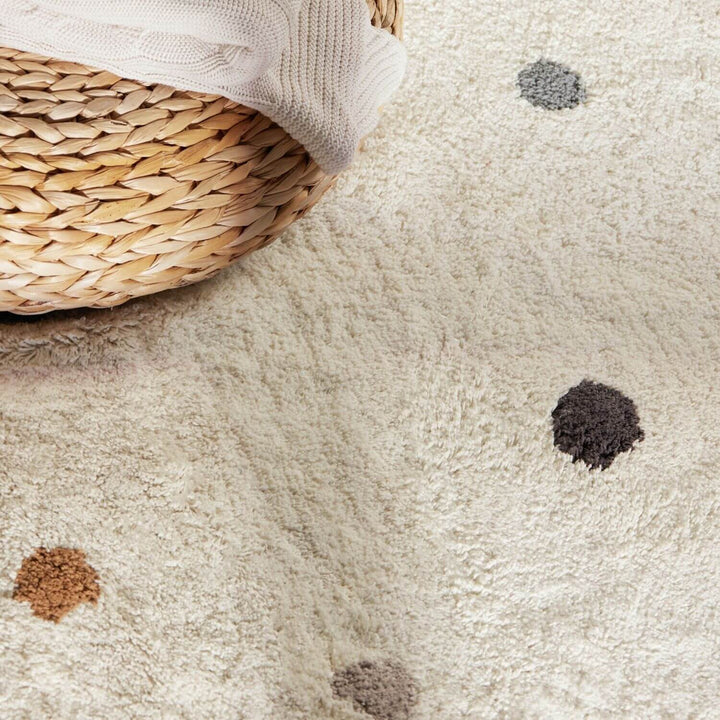 Close-up of a textured beige carpet with dark spots and a woven basket.