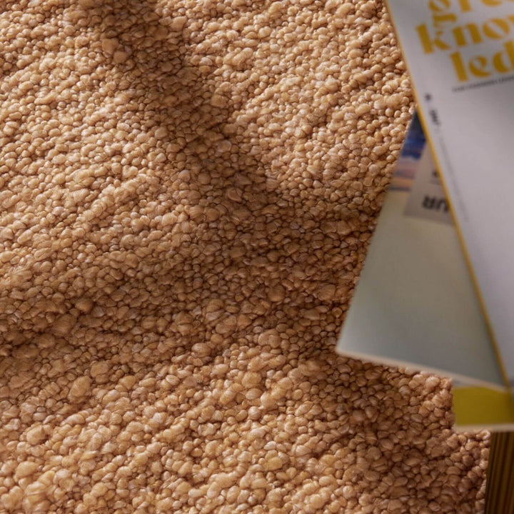 Close-up of a tube of toothpaste on a textured beige surface