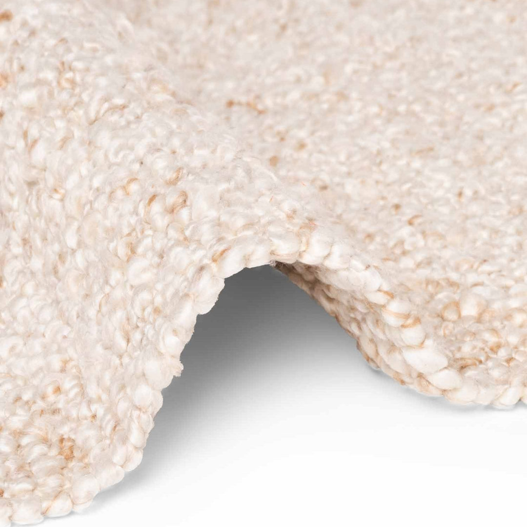 Close-up of a textured beige carpet corner