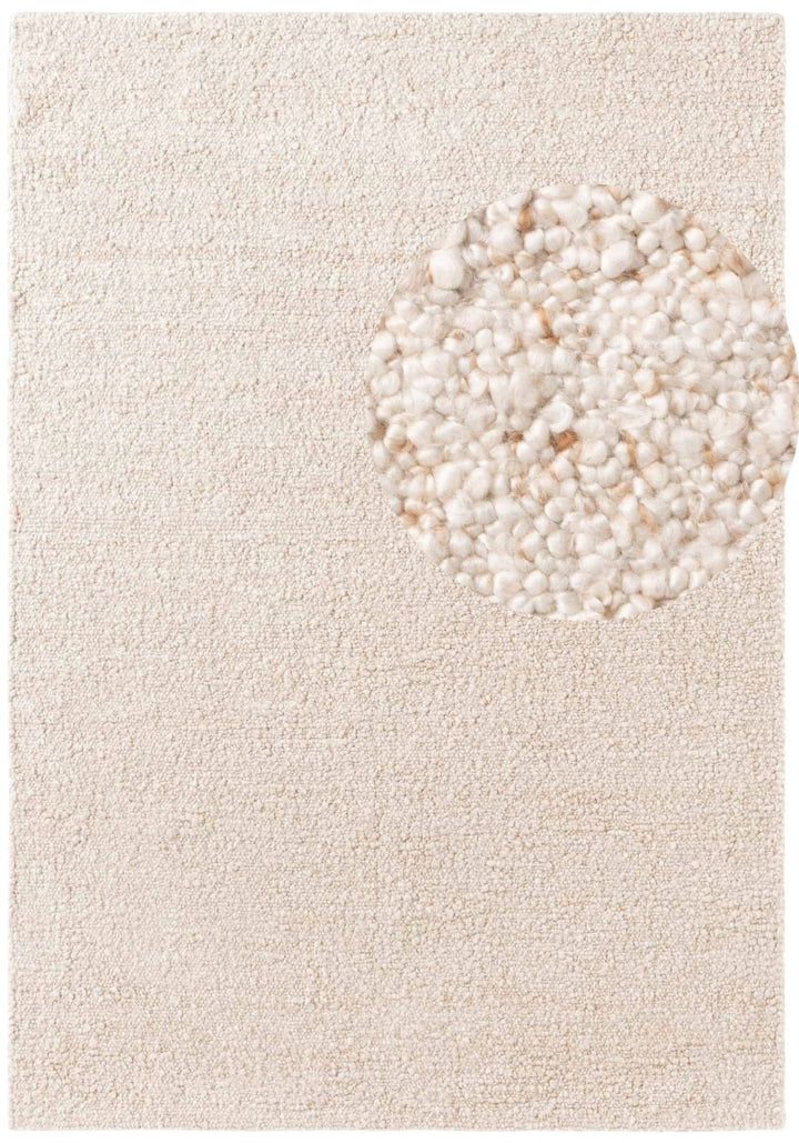 Beige rug with a circular pattern of smaller stones on a plain background