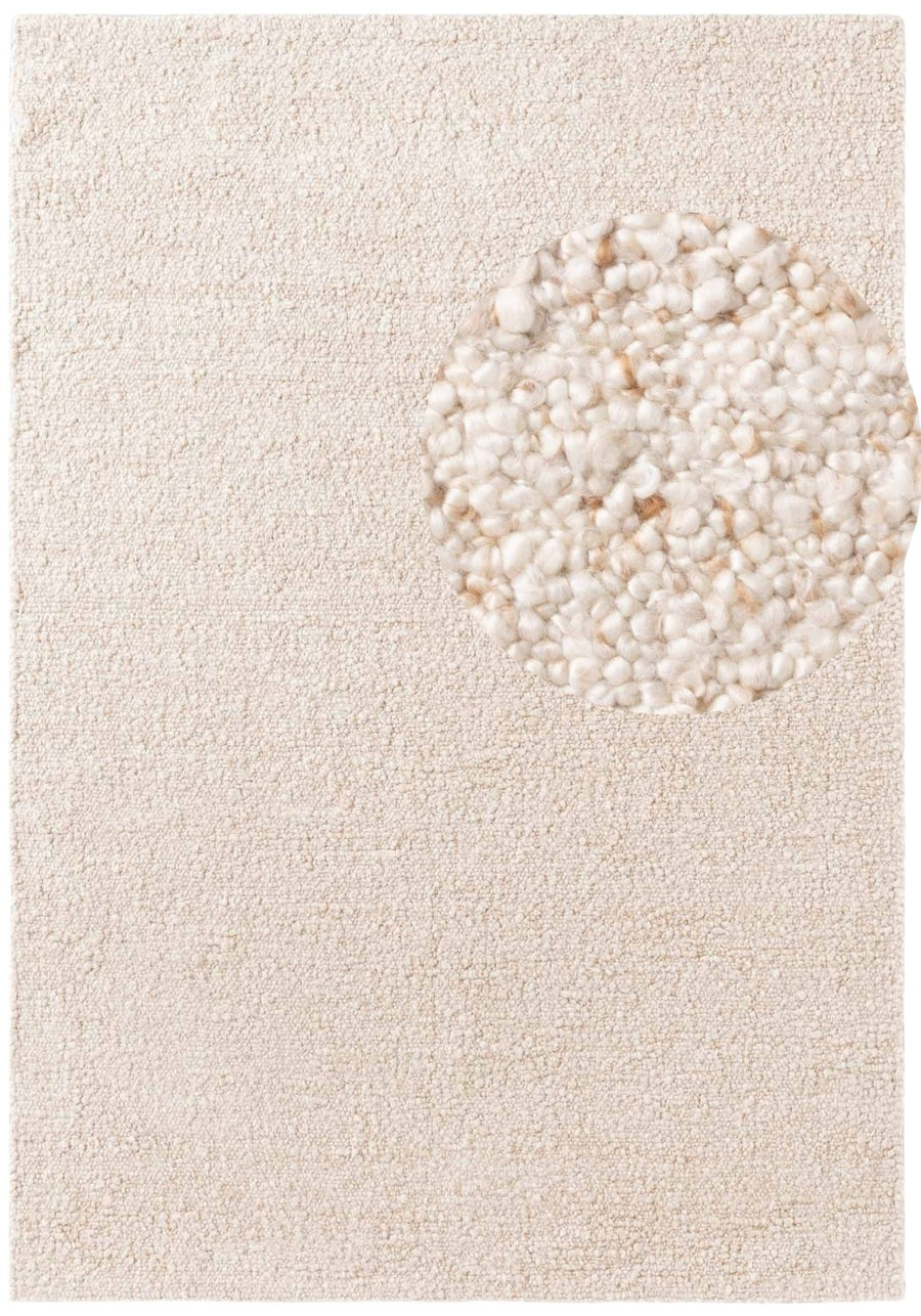 Beige rug with a circular pattern of smaller stones on a plain background