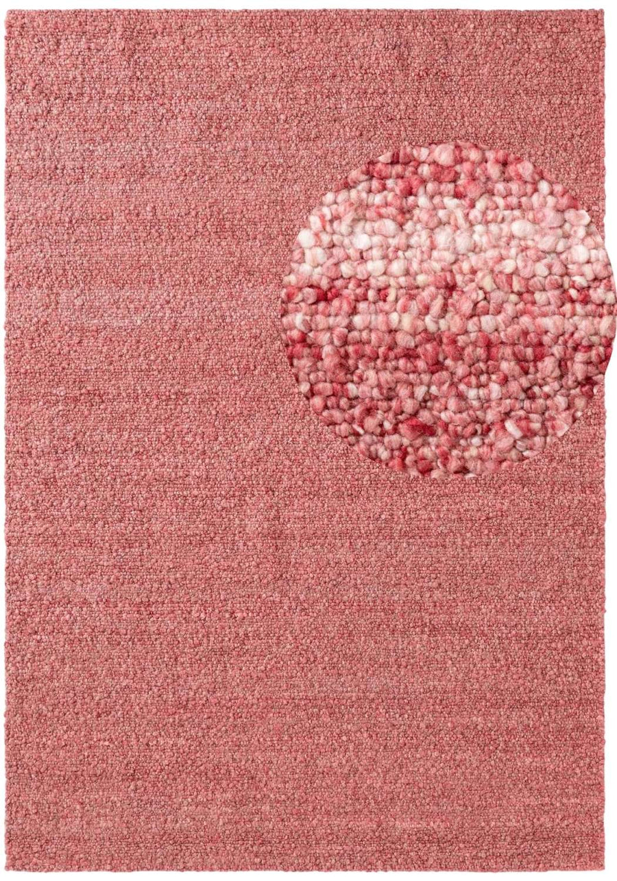 Pink textured rug with a circular pattern in the center