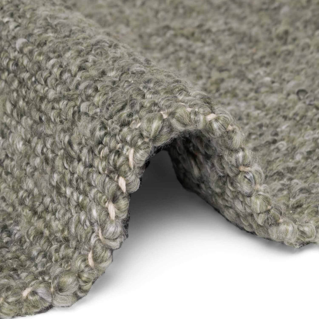 Close-up of textured green carpet roll on a white background