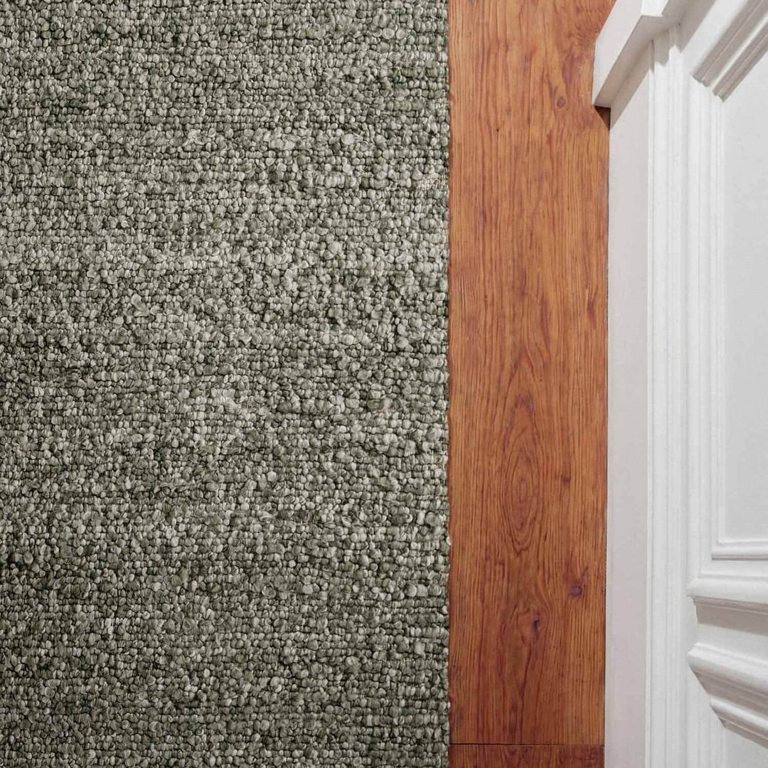 Transition from carpet to wooden floor with a white baseboard.