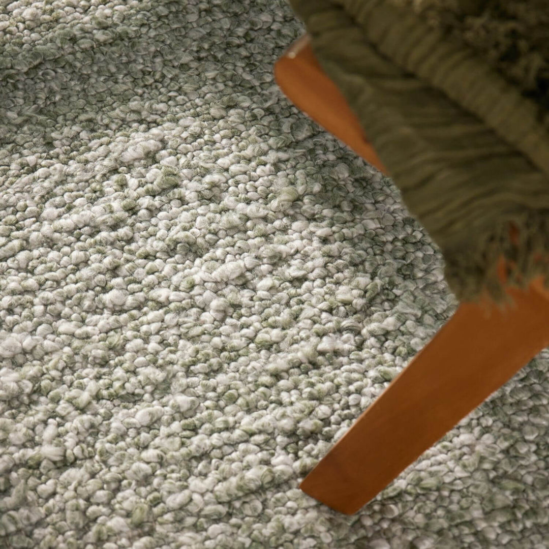 Close-up of a green carpet with a brown object partially visible