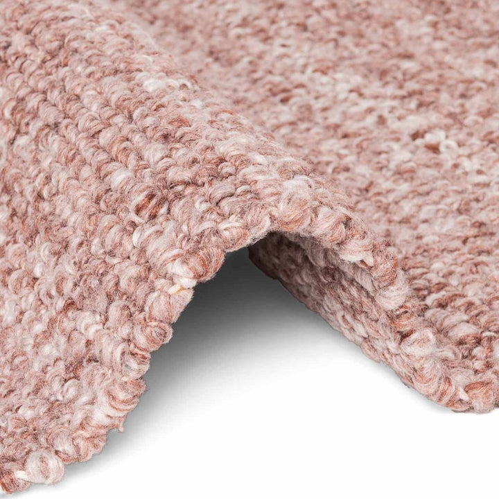 Close-up of a textured pink carpet corner on a white background