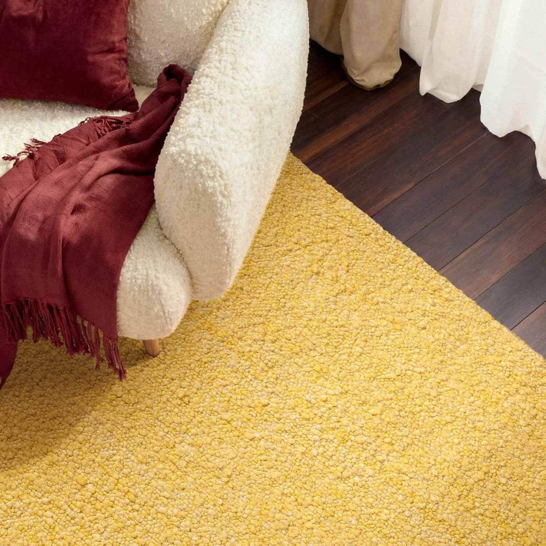 Yellow carpet with a white chair and red blanket in a room.