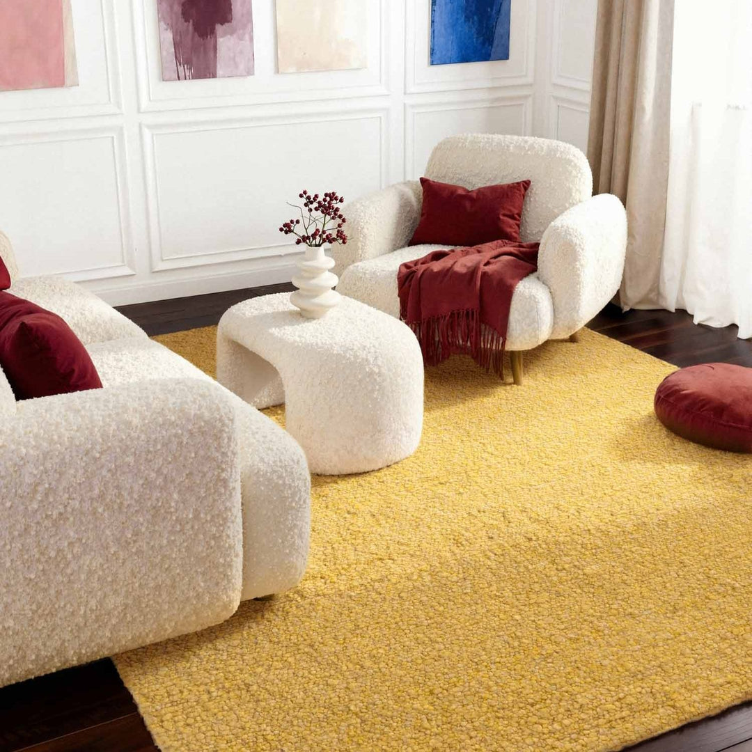 Modern living room with white armchairs, a yellow rug, and red accents.