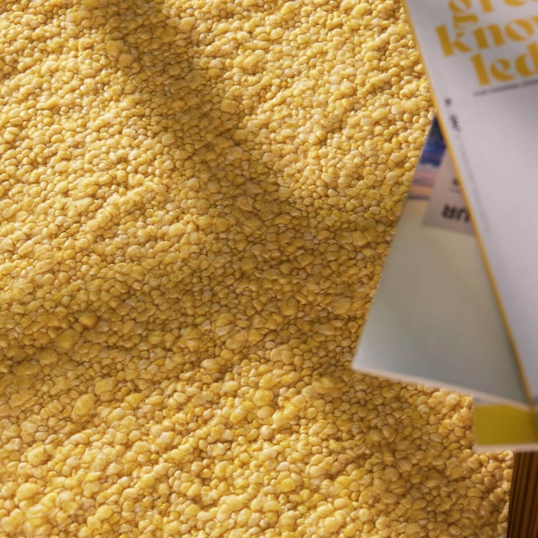 Close-up of a textured yellow surface with a book partially visible