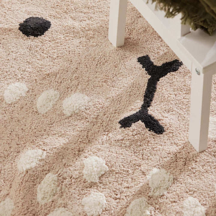 Close-up of a textured beige carpet with black and white patterns