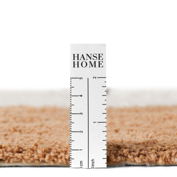 Close-up of a carpet sample with a ruler displaying &