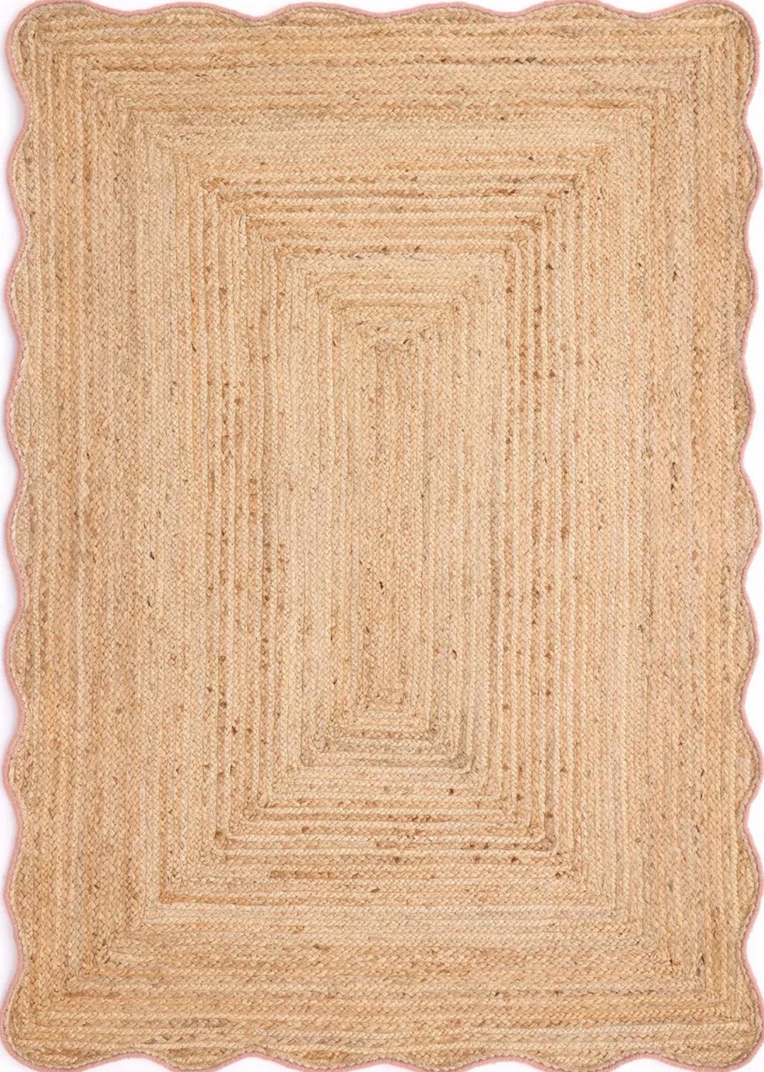 Beige braided rug with scalloped edge on a white background